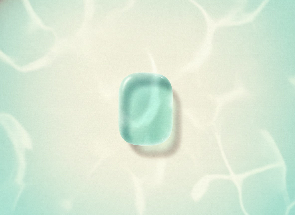 A smooth piece of aqua sea glass resting in sunlit water